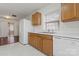 Traditional-style kitchen with white appliances and wood cabinets plus sliding door to the backyard at 133 Winding Canyon Dr, Charlotte, NC 28214