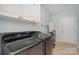 Well-equipped laundry room with modern washer and dryer, cabinets, and ample storage space at 140 Melbourne Dr, Fort Mill, SC 29708