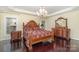 Spacious main bedroom featuring hardwood floors, elegant chandelier, tray ceiling, and luxurious furniture at 140 Melbourne Dr, Fort Mill, SC 29708