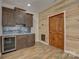 Modern bar area features wood wall accents, wood cabinets, and wine fridge at 1547 Sunset Pointe Dr, Salisbury, NC 28146