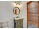 Bathroom featuring vanity with round mirror and wood accents that create a rustic and inviting atmosphere at 1547 Sunset Pointe Dr, Salisbury, NC 28146