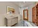 Bathroom featuring a vanity, marble countertop and a lighted mirror near a wood-paneled doorway at 1547 Sunset Pointe Dr, Salisbury, NC 28146