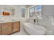 Beautiful bathroom features a soaking tub, marble wall accents, and modern vanity at 1547 Sunset Pointe Dr, Salisbury, NC 28146