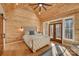 Comfortable bedroom featuring wood-paneled walls, natural light, and access to a private balcony at 1547 Sunset Pointe Dr, Salisbury, NC 28146