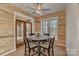 Cozy dining area with wood paneled walls, stylish lighting, and access to the outdoors at 1547 Sunset Pointe Dr, Salisbury, NC 28146