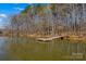 Lake view featuring a private dock surrounded by trees and a glimpse of the waterfront at 1547 Sunset Pointe Dr, Salisbury, NC 28146