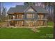 Stately two-story home featuring stone and siding, balconies, and multiple entry points to a large green lawn at 1547 Sunset Pointe Dr, Salisbury, NC 28146