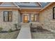 Close-up of the front entrance with stone accents and a wooden door at 1547 Sunset Pointe Dr, Salisbury, NC 28146