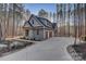 Side view of home featuring three-car garage, driveway, and lush greenery at 1547 Sunset Pointe Dr, Salisbury, NC 28146