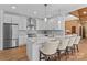 Modern kitchen featuring white cabinets, marble countertops, stainless steel appliances, and bar seating at 1547 Sunset Pointe Dr, Salisbury, NC 28146