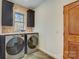 A modern laundry room with front loading washer and dryer, ample counter space and black cabinets at 1547 Sunset Pointe Dr, Salisbury, NC 28146