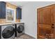 Laundry room featuring modern washer and dryer on marble floors and natural wood accents at 1547 Sunset Pointe Dr, Salisbury, NC 28146