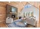 Cozy living room with stone fireplace, wood paneling, and ample seating at 1547 Sunset Pointe Dr, Salisbury, NC 28146