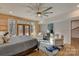 Bright main bedroom features wood accent wall, ceiling fan, sitting area, and access to outdoor area at 1547 Sunset Pointe Dr, Salisbury, NC 28146