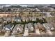 An aerial view shows a neighborhood with well-maintained homes, landscaped yards, and mature trees near a lake at 15913 Robbins Green Dr, Cornelius, NC 28031