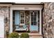 Charming front porch with stone accents, a bench, and a welcoming blue door and shutters at 15913 Robbins Green Dr, Cornelius, NC 28031