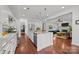 Bright, open kitchen with stainless steel appliances, granite countertops, island and hardwood floors, and a view to the living room at 15913 Robbins Green Dr, Cornelius, NC 28031