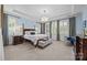 Spacious main bedroom with tray ceilings, large windows, and luxurious furnishings at 15913 Robbins Green Dr, Cornelius, NC 28031
