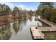 A scenic view showcases a peaceful pier overlooking the water with walkways connecting to the shoreline at 15913 Robbins Green Dr, Cornelius, NC 28031