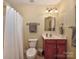 Cozy bathroom with white shower curtain and a cherry wood vanity at 1796 Williamsburg Dr, Rock Hill, SC 29732