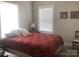 Comfortable bedroom featuring a twin bed with patterned red quilt, side table, and natural light from the window at 194 Hattaway Cir, Mount Gilead, NC 27306