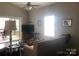 Open living room with neutral furniture, tv over cabinet, a view to the back deck, and bright window at 194 Hattaway Cir, Mount Gilead, NC 27306