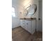 Bathroom with a double sink vanity featuring granite countertops and round black framed mirrors at 200 Hillcrest Ave, Hickory, NC 28601