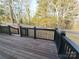 A wooden deck area with black railings overlooks a green yard and trees at 200 Hillcrest Ave, Hickory, NC 28601