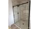 Modern bathroom shower with glass door, marble-style tile, and bronze hardware at 200 Hillcrest Ave, Hickory, NC 28601