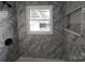 Close up of a shower with marble style tiling and bronze fixtures at 200 Hillcrest Ave, Hickory, NC 28601