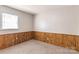 Unfinished basement area featuring wood paneled wainscoting, carpet, and a window for natural light at 208 Caleb Rd, Shelby, NC 28152