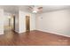 Bedroom features wood laminate flooring, neutral paint, a ceiling fan, and a view into the hallway at 208 Caleb Rd, Shelby, NC 28152