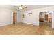 Bright living room featuring neutral walls, ceiling fan, and arched doorway leading to a wood-paneled room at 208 Caleb Rd, Shelby, NC 28152