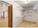 Spacious walk-in closet with ample shelving and wooden bi-fold doors with view to living room at 208 Caleb Rd, Shelby, NC 28152
