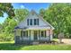 Charming two-story home with a covered front porch, American flag, and landscaped yard at 237 Mcneely Ave, Mooresville, NC 28115