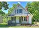 Cute bungalow-style house with a front porch, gray shutters, and an American flag at 237 Mcneely Ave, Mooresville, NC 28115
