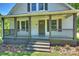 Inviting covered front porch with decorative columns, wood railings, and a charming entrance at 237 Mcneely Ave, Mooresville, NC 28115