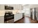 Well-appointed kitchen with stainless steel appliances, white cabinets, and hardwood floors at 237 Mcneely Ave, Mooresville, NC 28115