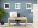 Home office with a wooden desk, black chair, potted plant, three windows, and a lamp at 2811 Morning Song Way, Lancaster, SC 29720