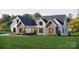 Beautifully designed home with stone and white siding, complemented by lush landscaping at 2910A Williams Rd, Matthews, NC 28105