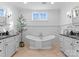 Bright bathroom with soaking tub, double vanity with granite counters, and paneled walls at 2924 Chelsea Dr, Charlotte, NC 28209
