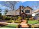 Charming Tudor-style home featuring a brick facade, arched doorway, and professionally landscaped front yard at 2924 Chelsea Dr, Charlotte, NC 28209