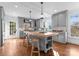 Bright kitchen features a center island with butcher block top, custom gray cabinets, and stainless appliances at 2924 Chelsea Dr, Charlotte, NC 28209