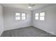 This bedroom is brightly lit with neutral walls, carpeted floors, a ceiling fan with a light, and two windows at 308 Dakota St, Kannapolis, NC 28083