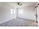 Bright bedroom featuring a ceiling fan, carpeted flooring, and a sliding barn door leading to the bathroom at 308 Dakota St, Kannapolis, NC 28083