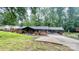 Charming brick home with dark shutters and a covered carport, surrounded by lush greenery and a well-manicured lawn at 308 Dakota St, Kannapolis, NC 28083