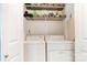 Functional laundry room with washer, dryer, storage shelving, and ironing board at 314 S Bruns Ave, Charlotte, NC 28208