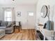Bright living room with laminate wood flooring, gray sofa, and console table at 314 S Bruns Ave, Charlotte, NC 28208