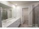Bright bathroom featuring double sinks, a large mirror, and a tiled shower, complemented by a spacious walk-in closet at 3207 Lisburn St, Charlotte, NC 28227