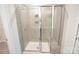 Modern tiled shower with glass doors and built-in shelving providing a luxurious and convenient bathing experience at 3207 Lisburn St, Charlotte, NC 28227